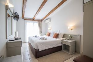 a bedroom with a large bed with a window at Parnassos Delphi Hotel in Delphi