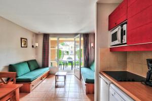 een keuken en een woonkamer met een bank en een tafel bij La résidence du Lac - maeva Home - Appartement 2 Pièces 5 Personnes - Sél 294 in Monflanquin