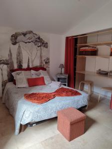 a bedroom with a bed with a red blanket on it at Chez Monique et Rémi in Avignon