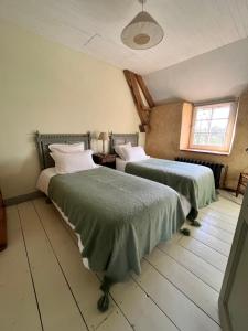 1 dormitorio con 2 camas y ventana en Domaine du tertre ychot en Dol-de-Bretagne