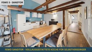 cocina y comedor con mesa de madera y sillas en NEU SandAPART32 - 3 tolle FeWos von 1-8 Pers mitten in der Altstadt en Bamberg