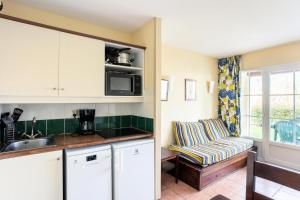 une cuisine avec un évier et un canapé dans une chambre dans l'établissement Résidence Les Belles Rives - maeva Home - Appartement 2 pièces 5 personnes - Confort MAE-4334, à Argentat