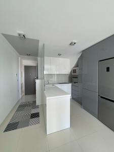 una cocina blanca con encimera y electrodomésticos blancos en Elisa Bay apartment Mil Palmeras, en Torre de la Horadada