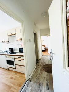 a kitchen with white cabinets and a wooden floor at Serendipity 3 in Pécs