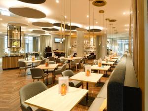 a restaurant with tables and chairs and a cafeteria at Holiday Inn Stuttgart, an IHG Hotel in Stuttgart