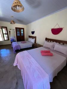 a bedroom with two beds with pink sheets at Pousada Varanda da Serra in Cavalcante