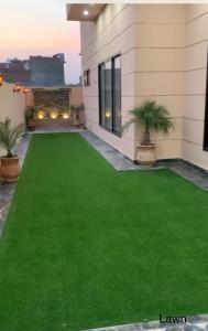 a fake lawn in front of a house at Holiday Home Family & Groups in Gujrāt