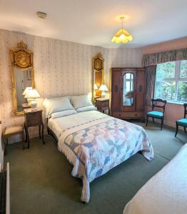 a bedroom with a large bed and two chairs at Gleneven Guest House in Inniskeen