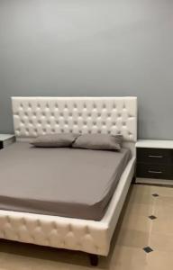 a white bed with a white headboard in a bedroom at Holiday Home Family & Groups in Gujrāt
