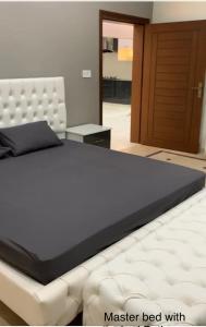 1 dormitorio con 1 cama con marco blanco en Holiday Home Family & Groups, en Gujrāt