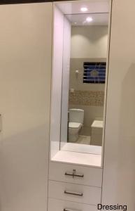 La salle de bains est pourvue de toilettes et d'un miroir. dans l'établissement Holiday Home Family & Groups, à Gujrāt