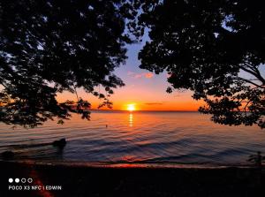 una puesta de sol sobre el agua con un barco en el agua en Los Chocoyos en Mérida