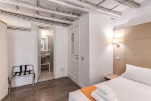 a bedroom with white walls and a bed and a desk at Magenta Collection Cancello in Rome