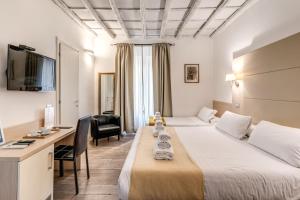 a hotel room with two beds and a desk at Magenta Collection Cancello in Rome