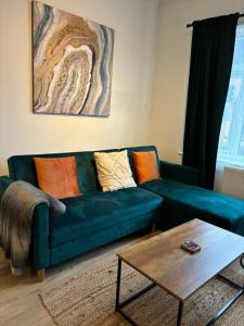 uma sala de estar com um sofá verde e uma mesa em Large 3 Bed House - Awsworth - J26 M1 - Ideal for Contractors or Families - Sleeps - 6 
