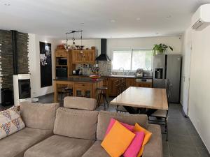 uma sala de estar e cozinha com um sofá e uma mesa em Maison proche des Dentelles, et du Mont-Ventoux em Aubignan