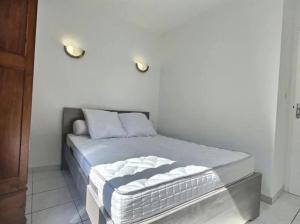 uma cama num quarto com duas luzes na parede em Appartement plein centre 300m de la plage . em Valras-Plage