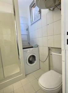 uma casa de banho com um WC e uma máquina de lavar roupa em Appartement plein centre 300m de la plage . em Valras-Plage