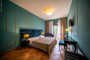 アーバノ・テルメにあるホテル テルメ ミラノの青い壁のベッドルーム1室(ベッド1台付)