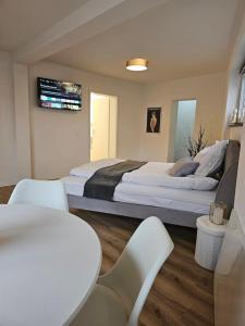 a bedroom with a large bed with chairs and a table at Die Alte Apotheke _ Apartment Nr.2 in Baiersbronn