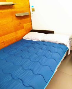 a bed with a blue comforter in a room at Casetta Belvedere in Naples