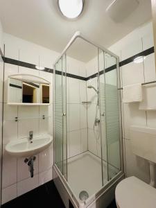 a bathroom with a glass shower and a sink at Pension Liechtenstein in Vienna