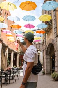 un homme debout devant un groupe de parapluies dans l'établissement Hotel Plaza Central Canning, à Ezeiza