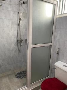 una doccia con porta in vetro in bagno di Luxury Elegance Residence a Kampala