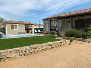 uma casa com uma parede de pedra e uma piscina em Maison proche des Dentelles, et du Mont-Ventoux em Aubignan