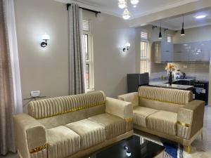 un soggiorno con 2 divani e una cucina di Luxury Elegance Residence a Kampala