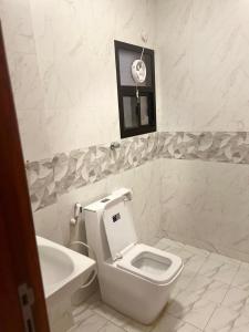 a white bathroom with a toilet and a sink at RED-22- ALSALAM suites in Salalah