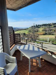 een witte tafel en stoelen op een balkon met uitzicht bij Fiori del Conero in Ancona