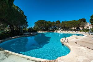- une piscine d'eau bleue dans un complexe dans l'établissement Village Pont Royal en Provence - maeva Home - Appartement 2 Pièces 6 Person 804, à Mallemort