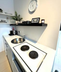 una cocina con fregadero y un reloj en la pared en Day Dream Mjostraeti 10a, en Reikiavik