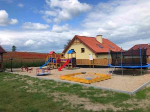 a playground with several slides and a play structure at Pokoje u Emilii in Mikołajki