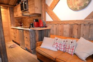 ein Wohnzimmer mit einem Sofa und einer Küche in der Unterkunft Résidence Necou - Studio pour 3 Personnes 954 in Les Menuires