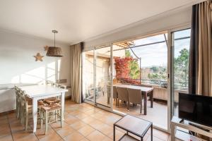 uma sala de estar com uma mesa de jantar e uma varanda em Village Pont Royal en Provence - maeva Home - Appartement 2 Pièces 6 Person 814 em Mallemort
