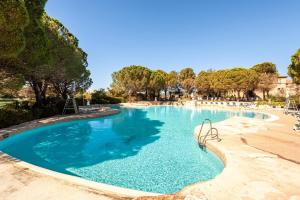 uma piscina com água azul e uma praia em Village Pont Royal en Provence - maeva Home - Appartement 2 Pièces 6 Person 814 em Mallemort