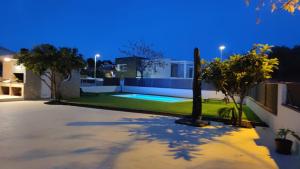 una villa con piscina di notte di Acogedora casa con piscina y 3 dormitorios a Vilanova i la Geltrú