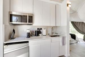 a white kitchen with a sink and a microwave at Unique Escapes - Modern Luxury Geodome in Monticello