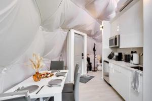 a white kitchen with a table and a white ceiling at Unique Escapes - Modern Luxury Geodome in Monticello