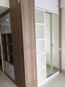 a closet with glass doors and shelves in a room at Ciumbuleuit Residence, Mountain View Apartment in Bandung