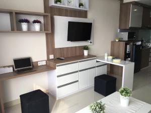a living room with a tv and a white kitchen at Ciumbuleuit Residence, Mountain View Apartment in Bandung