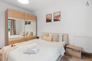 a bedroom with a large white bed and a mirror at Maia 1BDR with Parking in Mogoşoaia