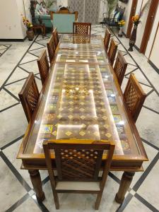 une grande table en bois entourée de chaises dans l'établissement Gupta Vilas - A Boutique Homestay, à Agra