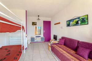 ein Wohnzimmer mit einem Sofa und einem Etagenbett in der Unterkunft Appart T2 30m2 2em Etage in Le Barcarès