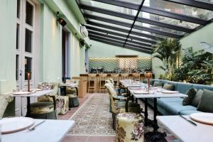 a restaurant with tables and chairs in a room at SAYA La Villa in Mar Mikhael in Beirut