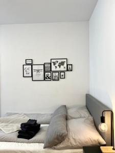 a bedroom with a bed with four pictures on the wall at Modernes Apartment im Zentrum von Karlsruhe in Karlsruhe