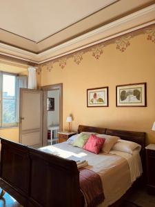 ein Schlafzimmer mit einem großen Bett mit rosa Kissen in der Unterkunft Palazzo Lucangeli in Porto Recanati