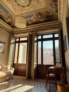 ein Wohnzimmer mit Kassettendecke und Fenstern in der Unterkunft Palazzo Lucangeli in Porto Recanati